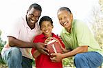 Grandfather With Son And Grandson In Park With American Football