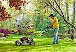 Man cutting grass during the spring in his backryard