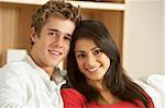 Young Couple Sitting On Sofa Together