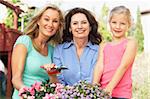 Senior Woman With Adult Daughter And Granddaughter Gardening Together