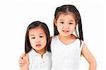 Asian sisters arms around on plain background