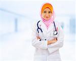 Confident Muslim female doctor standing inside hospital