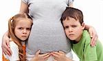 Grumpy kids not happy about their new sibling - listening to pregnant woman belly