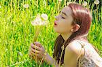 Little girl blowing dandelions, nine at the same time