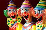 A row of sideshow carnival game clowns with mouths open.  Focus to middle clown.