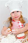 girl in chef's hat cooking dough for cake