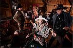 Sheriff and cowboys with weapons on cheating gambler