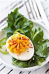 Curry eggs and green salad close up.