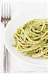 Fresh hot spaghetti with pesto on a plate.