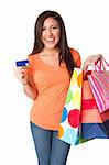 Beautiful Happy smiling young woman on shopping spree with credit card plastic money carrying colorful bags with merchandise presents, isolated.