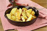 fresh potatoes fried in a pan on a wooden table