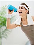 Healthy woman drinking water after workout