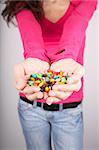 woman portrait holding lot of candy in her hands