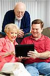 Son teaching his elderly parents how to use a new tablet PC.