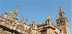 Detail of the gothic and baroque Cathedral of Seville and the famous bell tower called La Giralda that was previously a minaret of the Berber Almohad period in Spain.