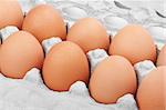 Closeup of many fresh brown eggs in carton tray