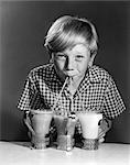 ANNÉES 1960 ANNÉES 1950 PORTRAIT DE GARÇON BLOND AVEC DEUX PAILLES À BOIRE DE 3 SODAS MILKSHAKES SOURIANT LOOKING AT CAMERA