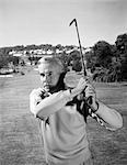 1960s MAN PLAYING GOLF HITTING GOLF BALL FROM FAIRWAY WITH IRON CLUB