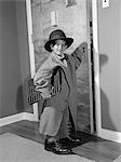 1950s BOY DRESSED IN FATHER'S CLOTHES HOLDING ATTACHÉ CASE OPENING DOOR OF HOUSE AS IF GOING OFF TO WORK