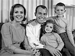 1960s SMILING FAMILY PORTRAIT MOTHER FATHER SON DAUGHTER LOOKING AT CAMERA