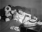 1950s SICK LITTLE GIRL IN BED PLAYING WITH RECORD PLAYER