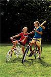 1980s 1990s JUVENILE BOY AND TEENAGE BOY ON BICYCLES WITH BASEBALL BAT AND GLOVE