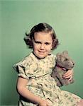 1950s PORTRAIT SMILING TODDLER GIRL HOLDING STUFFED ANIMAL TOY