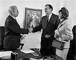 ANNÉES 1960 COUPLE MARI ET FEMME SECOUANT LES MAINS AVEC L'ENTREPRISE GESTIONNAIRE DU PRÊT BANCAIRE INTÉRIEUR