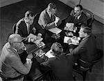 1950s GROUP OF SIX MEN TALKING AROUND A  CONFERENCE TABLE