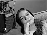 1960s TEENAGE GIRL LISTENING TO PORTABLE RADIO WISTFUL EXPRESSION INDOOR