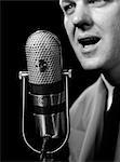 1950s CLOSE-UP OF MAN ANNOUNCER TALKING INTO MICROPHONE NEWSCASTER INDOOR SYMBOLIC FREEDOM OF SPEECH