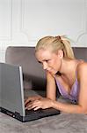 Smiling woman using laptop on couch