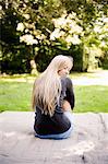 Woman sitting on blanket in park