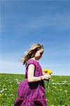 Girl carrying wildflowers in field