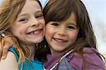 Smiling girls hugging outdoors