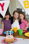 Smiling girls hugging at birthday party