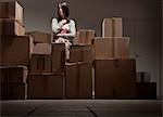 Teenage girl in pile of cardboard boxes