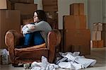 Teenage girl in armchair in new home