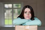 Teenage girl leaning on cardboard box