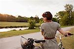 Woman walking bicycle on rural road