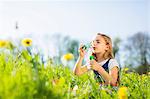 Girl blowing bubbles in field