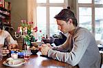 Man using cell phone at dinner table