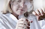 Girl pouring liquid into beakers