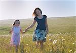 Mother and daughter walking in field