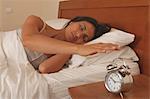 Woman turning off alarm clock