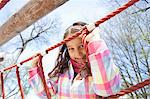 Girl climbing ropes in playground
