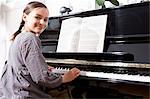 Smiling girl practicing at piano