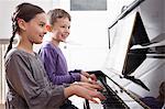 Brother and sister playing piano