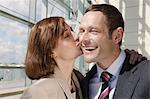 Mid adult couple, woman kissing man on cheek
