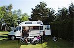 Couple manger petit déjeuner à l'extérieur du camping car